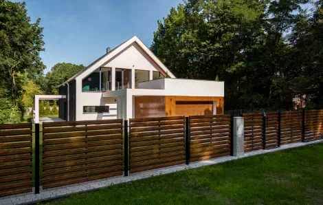widok nowoczesnego domu z drewnianym ogrodzenie
